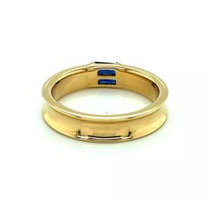 An elegant and authentic stack ring from Tiffany & Co. It is crafted from 18k yellow gold with a polished finish and features a 4.5mm wide concave design around the entire band with two channel set baguette sapphires.  It is signed by the designer with the gold content.    Brand:   Tiffany & Co.  Hallmark:  1997 Tiffany & Co. 750  Sapphire: 0.30ct  Material:  18k yellow gold  Measurement:  0.19" wide x 0.11" high  Ring Size:  6  Weight: 5.8 grams Stack Ring, Channel Set, Stacking Rings, Tiffany & Co., Band Ring, A 4, Hallmark, Band Rings, Sapphire