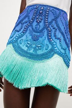 Borrowing From The Art Deco Era, This Opulently Beaded Ombre Mini Skirt Blends Swishy Tassels With A High-Rise Fit And Undeniably Glamorous Vibe. The Tassels Come Cut In A Draped, Asymmetric Line, Giving This High-Voltage Piece A Beautiful Sense Of Movement.Style: Skirtdesign: Embroideredfabric: Wovenlength: Mini Beaded Fringe Skirt, Fringe On Clothes, Beaded Mini Skirt, Bohemian Party Bottoms With Tassels, Spring Party Mini Skirt With Rhinestone Fringe, Summer Embellished Blue Skirt, Embellished Blue Skirt For Summer, Summer Blue Embellished Skirt, Spring Bohemian Embellished Skirt