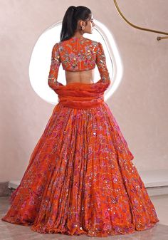 Presenting a captivating lightweight lehenga in a vivid orange hue, elegantly printed and designed with luminous lurex chiffon. This voluminous piece is beautifully enhanced with sequin details for a touch of sparkle. Paired with a coordinated blouse featuring full sleeves, intricate embroidery, and a sophisticated closed-back design, along with a striking ruffled dupatta to complete the chic ensemble. Sensation style for a Sangeet or Reception ! Composition : Lehenga, Blouse, Dupatta - Lurex Chiffon Care: Dry Clean Only and Vacuum Storage This product can be customized for sleeves, length of blouse and neckline Delivery : 4-6 weeks as the product is hand crafted. Check Size Guide or choose MySize for free customisation (All Sizes above XL can be made at 15% additional cost) For more infor Lightweight Lehenga, Mahima Mahajan, Ruffle Dupatta, Lehenga Style Saree, Indian Bridesmaid Dresses, Lehenga Style, Vacuum Storage, Embroidered Lehenga, Indian Wedding Wear