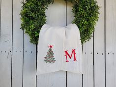 a towel hanging on the side of a wooden wall with a christmas tree and letter m