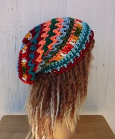 "OOAK handmade crochet beanie, with random colored zigzagging stripes. \"Eclectic Mix\" contains blues, teal, green and variegated yarns. The length and width is suitable for dreadlocks (short to medium). Width at brim 20\", stretches to 25\", cinches smaller with drawstring Length from crown to rim 10,5\"  Widest point across 11\" All hypo-allergic acrylic yarn.  I suggest hand-washing and flat-drying, care suggestions come in each package." Crochet Hippie Hat, Adjustable Bohemian Beanie Cap, Bohemian Slouchy Crochet Hat For Beach, Colorful Bohemian Crochet Hat, Funky Handmade Beanie Hat, Bohemian Beanie One Size Fits Most For Festival, Bohemian Adjustable Beanie For Fall, Bohemian Beanie For Festivals, Red Bohemian Crochet Beanie Hat