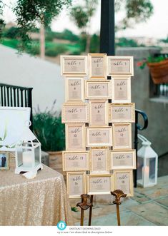 a table topped with lots of small wooden frames next to a white and gold table cloth