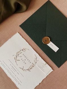 an envelope with a wax stamp on it next to a card and some other items