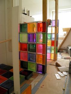 colorful glass blocks are stacked on top of each other in a room that is being remodeled