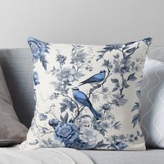 two blue birds sitting on top of a white pillow