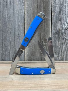 a blue pocket knife sitting on top of a wooden table