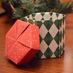 two origami boxes sitting next to each other on top of a wooden table