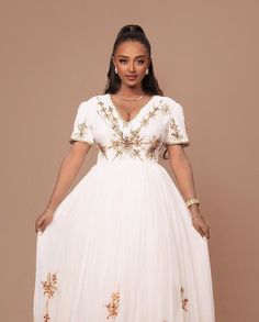 This stunning Habesha dress features a beautiful combination of Menen fabric in a deep shade of blue, with a Shimena fabric bottom that adds a touch of elegance and sophistication. The dress is designed to be both flattering and comfortable, with a fitted bodice that accentuates the curves and a flowing skirt that drapes gracefully over the hips and legs. The unique and intricate Tilf embroidery design adds a touch of glamour and sophistication to the garment, with delicate beadwork that creates Eritrean Dress, Ethiopian Clothing, Ethiopian Traditional Dress, Ethiopian Dress, Habesha Kemis, Flowing Skirt, Fitted Bodice, Stunning Dresses, Formal Event