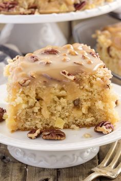 a close up of a piece of cake on a plate with pecans around it