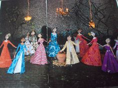 there are many dolls that are standing in front of a brick wall with chandeliers hanging from it