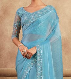 COLOR : Sky Blue FABRIC : Saree - Chiffon Silk, Blouse - Chiffon Silk & Net WORK : Resham Embroidery, Stones, Sequins, Lace BorderOCCASION : Wedding, Engagement, Party Wear, Festival, Sangeet NOTE : The outfit includes blouse and saree only. Petticoat is not included. READY-TO-WEAR : No STITCHING : Available as semi-stitched fabric, can be stitched using standard size option (+$30). Note: There might be a slight color variation due to lighting and flash used during photoshoot. The bright shade s Blue Blouse With Sheer Dupatta, Blue Organza Sets With Dori Work, Blue Blouse With Dupatta For Festive Occasions, Blue Blouse For Eid Reception, Blue Elegant Blouse For Eid, Blue Dupatta Blouse For Eid, Blue Blouse With Dupatta For Eid, Formal Blue Saree, Fitted Light Blue Blouse Piece For Wedding