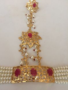 This beautiful haathphool is made using genuine pearls and Cubic Zirconia (CZ) polki stones with 22 Carat (CT) gold plating. It includes one pair of haathphools, perfect for any special occasion. Order yours today! Features Intricate Pair of Hathphool Set with fine pearls and genuine Rubies 22 carat gold plating an elegant touch Fine Quality CZ Polki glitters in the light These bracelets are made using pearls and CZ polki with 22-carat gold plating including one pair of beautiful haathphool acce Hathphool Gold, Bracelets Indian, Haath Phool, Hyderabadi Jewelry, Jadau Jewellery, 22 Carat Gold, Wedding Jewellery Collection, Silver Jewelry Earrings, Pakistani Jewelry