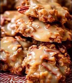 some cookies are stacked on top of each other with pecans in the middle and drizzled over them