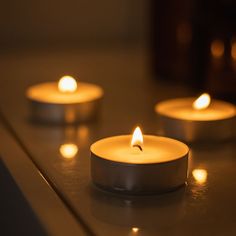 three lit candles sitting on top of a counter