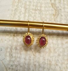 14k gold earrings, Garnet earrings, January birthstone earrings, Antique inspired earrings, vintage earrings, Red oval earrings These antique inspired red Garnet earrings were 100% handmade. The see through wine red Garnet stones are just beautiful and shine softly against the gold contour of the earrings. These January Birthstone earrings are just the perfect gift for yourself or someone you love. They can be great gold bridal earrings. Dimensions: The earrings drop length is 2.5cm or 1 inch Th Vintage Gold Gemstone Earrings, 14k Gold Cabochon Earrings Gift, Antique Oval Gemstone Earrings, Elegant Gold Garnet Cabochon Jewelry, Heirloom Oval Gold Earrings, Victorian Gold Gemstone Earrings, Oval Brass Earrings For Formal Occasions, Formal Oval Brass Earrings, Heirloom 14k Gold Oval Earrings