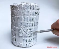 a person is using a small brush to paint the bottom of a roll of toilet paper