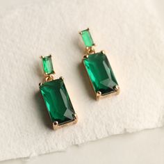 These great earrings are brass and feature a simple and classic rectangular baguette design.  The tiny cubic zirconia jewels are cut into perfect rectangles.  The baguette cut stones are glass in a beautiful, cool toned emerald green shade.   The earrings measure 30mm (just over an inch) in length and have gold plated ear wires.   This piece of handmade jewellery comes packaged in a nice recycled gift box with a handmade tag, all ready to give or keep. 🖤 FASTER SHIPPING 🖤 Need this fast? We offer a Faster Shipping option here: https://www.etsy.com/uk/listing/100107311/faster-shipping-priority-post-upgrade Please read the description before purchasing this listing, as we are unable to post every day! 🖤 GIFT MESSAGE & WRAP SERVICE! 🖤 For those of you who are sending gifts straight to you Elegant Rectangular Emerald Earrings For May Birthstone, Elegant Rectangular May Birthstone Earrings, Formal Rectangular Earrings With May Birthstone, Classic Green Earrings For Party, Green Rectangular Jewelry For Party, Elegant Green Rectangular Earrings, Classic Rectangular Party Earrings, Emerald Rectangular Earrings For May Birthstone, Gold Emerald Rectangular Earrings