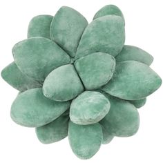 a green flower shaped pillow sitting on top of a white surface