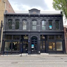 an old black building on the corner of a street