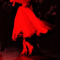 a woman in a red dress is dancing