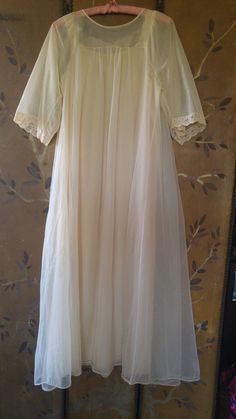 "60's lovely light beige nylon peignoir maxi nightie and sheer matching gown set. The nightie has beige lace shoulders and around front of the neck with brown eyelet embroidery across neck. The hem is lace also. The Gown is sheer double fabric. Same detail as nightie at front of the neck, it does up with two small buttons at the front of neck. mid length wide sleeves with lace at ends. Nightie : arm to arm across 18\" (36 bust) length 52\" **A few teeny tags in outer gown**" Fitted Cream Nightgown For Wedding, Cream Lace Wedding Nightgown, Wedding Cream Lace Nightgown, Cream Lace-trim Sleepwear For Wedding, Cream Wedding Sleepwear With Lace Trim, Cream Wedding Night Gown With Lace Trim, Cream Sheer Nightgown For Sleep, Sheer Cream Nightgown For Sleep, Sheer Cream Nightgown For Wedding Night