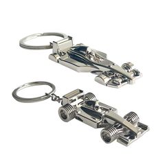 two metal key chains that are shaped like a racing car with wheels on each side