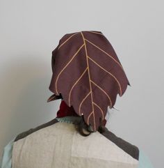 the back of a person's head wearing a hat with leaves on it