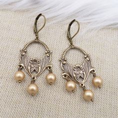 These art nouveau style earrings were handmade by ME with top quality elements.  The chandelier links are stamped brass hollow backed metal that is professionally antiqued to a warm rich antique patina.  To these I added top quality crystal cored faux pearls in the color called Vintage Gold.  These are light and comfortable and look great on the ears!  Total length including the brass lever back ear wires is 2 1/4 inches with a 3/4 inch width.  Thank you - shop my collection here:  www.etsy.com/shop/hhjewelrydesigns Earrings Gold Pearl, Art Nouveau Earrings, Art Nouveau Earring, Jewelry Classic, Flower Chandelier, Nouveau Jewelry, Art Nouveau Style, Pearl Flower, Style Earrings