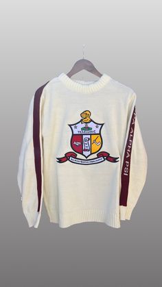 Exclusive Kappa Alpha Psi Chenille Appliqué Embroidery Crimson Sweater. This is the perfect long-sleeved Sweater to wear while showing off your Kappa Alpha Psi fraternity . A comfortable 100% Acrylic with a Chenille K diamond and Kappa Alpha Psi embroidery across the chest give you the perfect fit. This sweater is also a perfect gift for your favorite Kappa Man. Fast Shipping & Processing: 1-2 days to process US Domestic Shipping: 3-5 business days International Shipping: 7-14 business White Long Sleeve College Sweater, White Long Sleeve Sweater For College, White Outerwear With Embroidered Graphics, White Long Sleeve Outerwear With Embroidered Graphics, White Embroidered Logo Sweater For Fall, White Collegiate Winter Sweater, Fitted Embroidered Crew Neck Sweater, White Embroidered Crew Neck Outerwear, Fitted Long Sleeve Tops With Embroidered Graphics