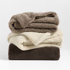 three towels stacked on top of each other in brown and white colors, with one folded up