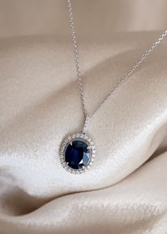 The beautiful blue color of this Sapphire gemstone makes this necklace a true show-stopper. We've set this 2.90ct Oval Cut Blue Sapphire in a White Gold pendant with a 0.29ctw Diamond Halo. Looking for a memorable birthday or anniversary gift? This bold pendant is perfect! Details: Gemstone: Sapphire Metal: 14K White Gold Chain, 18K White Gold Setting Gem Color: Blue Weight: 2.90ct Sapphire, 0.29ctw Diamond Gem Cut: Oval Quality: 100% Natural Gemstone 32 x 0.29ctw Diamond Halo Certified Blue Sapphire We can design any gemstone pendant specified in your style. Our inventory of gemstones makes it easy to design a masterpiece within your budget. Feel free to text us directly at 972-404-4499 to speak with a jewelry specialist. Want to see more photos📷 and videos 🎥 of our jewelry? Follow us o Elegant Blue Diamond Pendant Necklace, Dazzling Blue Necklace With Brilliant Cut, Blue Diamond Necklace For Formal Occasions, Blue Luxury Diamond Necklace For Anniversary, Luxury Blue Diamond Necklace For Anniversary, Luxury Blue Diamond Necklace For Formal Occasions, Elegant Blue Diamond Necklace For Wedding, Blue Diamond Necklace For Wedding, Sapphire Diamond Cut Necklace For Weddings