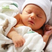 a baby is sleeping on a white blanket