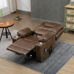 a brown recliner chair sitting on top of a rug next to a wooden table