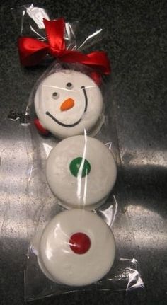 three snowmen are wrapped in plastic and have red bows on their heads, one is white