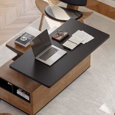 a laptop computer sitting on top of a wooden table next to a book and other items