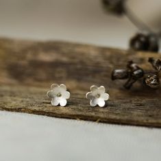 A pair of tiny flower earrings These earrings are made of 925 sterling silver and have a matte finish that makes them elegant and delicate. A gently hammered surface makes these studs every time different and unique. DETAILS: * Ø Diameter approx. 6 mm or 0.24 inch * Sterling silver earrings posts and butterfly backs * Matte finish All jewelry comes carefully and beautifully packed in a craft paper box, gift ready. You might also like these flowers: https://www.etsy.com/listing/694019223/black-fl Minimalist Sterling Silver Flower Charm Earrings, Delicate Sterling Silver Flower Earrings For Gift, Delicate Sterling Silver Flower Earrings As Gift, Hypoallergenic Sterling Silver Flower Earrings For Her, Minimalist Sterling Silver Flower Earrings, Minimalist Sterling Silver Flower Earrings Gift, Delicate Sterling Silver Birth Flower Earrings, Delicate Hypoallergenic Flower Earrings For Everyday Wear, Sterling Silver Flower Charm Earrings For Everyday