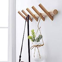 a white wall with a plant in a glass vase and some wooden shelves on it