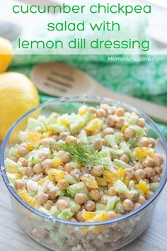 a glass bowl filled with chickpea salad next to lemons