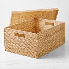 two woven storage baskets sitting on top of a white countertop next to each other