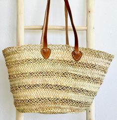 This sturdy Large Lace Straw Market Basket is handwoven from natural palm leaves for a unique and beautiful boho chic look. Its classic lace style and ancestral craftsmanship make it perfect for a farmers market haul or a day at the beach. Each basket is crafted with skill by female artisans. dimensions: height: 14", width: 19", base: 6" x 11" // 35cm H, 48cm W, 15*28cm baseleather strap: 10" high // 25cm style:two different styles of handles: braided or plain leather*because each basket is hand Natural Bohemian Straw Bag, Rectangular, Beach Purse, Eco-friendly Handwoven Basket Straw Bag, Bohemian Rectangular Straw Bag, Fair Trade, Bohemian Basket-shaped Natural Straw Bag, Natural Basket-shaped Handwoven Beach Bag, Morocco Style, Boho Purse, Lace Bag