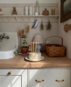 a kitchen counter with a cake on top of it and candles in front of the sink