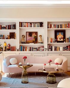 a living room filled with lots of furniture and bookshelves covered in bookcases