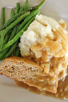 green beans and mashed potatoes with gravy on a white plate