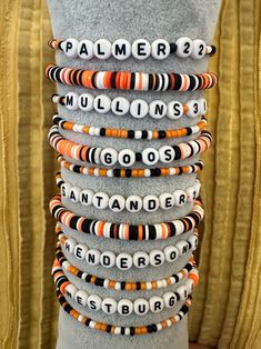 a stack of bracelets on top of a mannequin's torso in front of a gold curtain