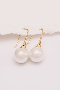 Sleek and chic, these minimal pearl earrings are trendy, yet timeless. Perfect for brides or everyday wear. Dimensions: Hangs 1.5", Pearl is 14mm Materials: Simulated Pearl, Copper, 18k Gold Plating Ships in a branded jewelry pouch and box, perfect for gift giving! Pearl Drop Earrings, Pearl Drop, Jewelry Pouch, Gift Giving, Gold Plating, 18k Gold, Pearl Earrings, Everyday Wear, Gold Plate