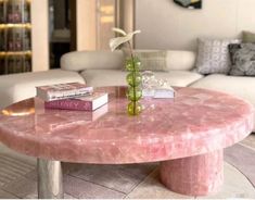 a pink marble coffee table with books on it