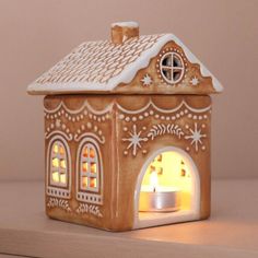 a gingerbread house with a lit candle inside