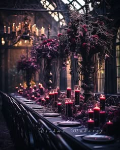 a long table with candles and flowers on it in front of a chandelier