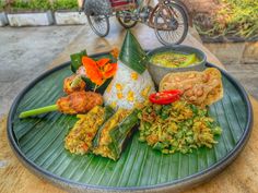 a plate full of food sitting on top of a table next to a bicycle parked in the background