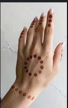 a woman's hand with small red flowers on her left wrist and the other half of her arm